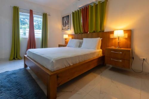 a bedroom with a large bed with green curtains at Litzie Apartment in San Felipe de Puerto Plata