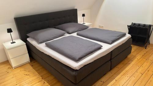 un grand lit avec deux oreillers dessus dans l'établissement Apartment Köln Bonn DeLux Burgblick, à Bornheim