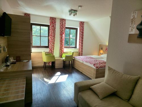 a hotel room with a bed and a couch at Berggasthof & Hotel Götzinger Höhe in Neustadt in Sachsen