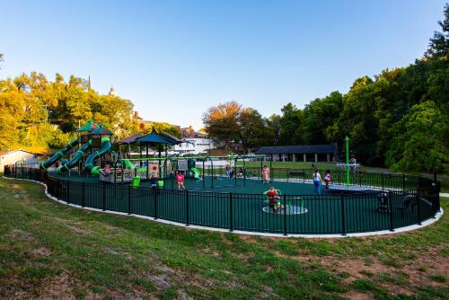 a playground in a park with people playing on it at The Woodford Hotel in Versailles