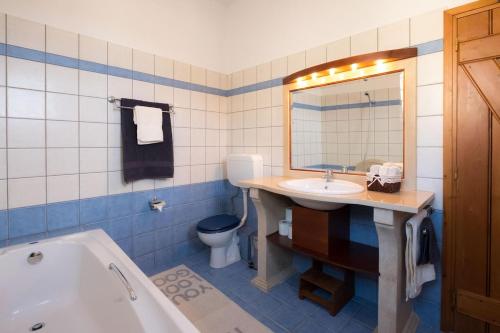 a bathroom with a tub and a sink and a toilet at Gaby's charming house in Kavoúsion