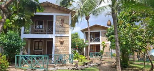 a house with palm trees in front of it at Pousada Cacimbinha in Pipa