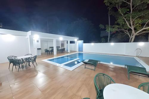a swimming pool with chairs and a table and a dining area at Villa do Porto Resindece in Porto De Galinhas