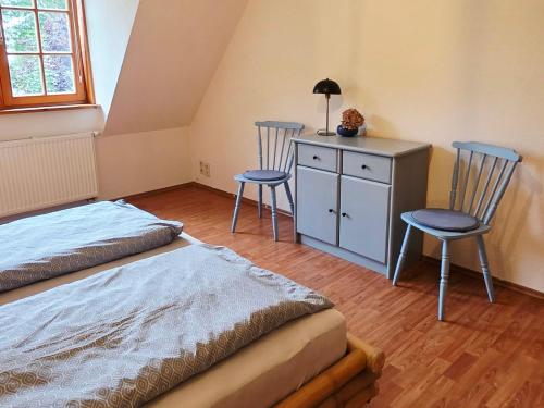 a bedroom with two chairs and a desk and a bed at Große Landhaus Wohnung 30 Min bis Hamburg in Klein Offenseth-Sparrieshoop