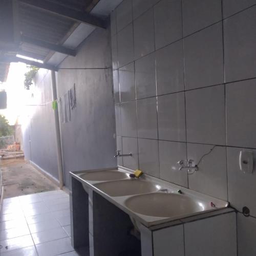 a bathroom with a tub and a tiled wall at Casa espaçosa, com ar condicionado em todos os quartos in Barra do Garças
