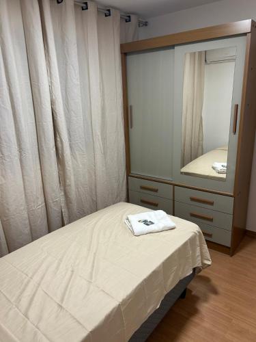a bedroom with a bed and a mirror at Apartamento completo, lindo e confortável em Duque de Caxias RJ in Duque de Caxias