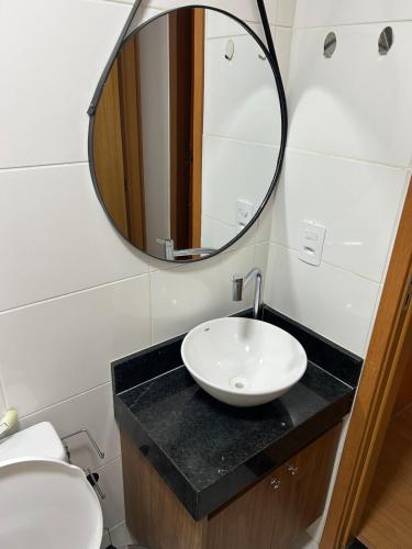 a bathroom with a sink and a mirror at Apartamento completo, lindo e confortável em Duque de Caxias RJ in Duque de Caxias