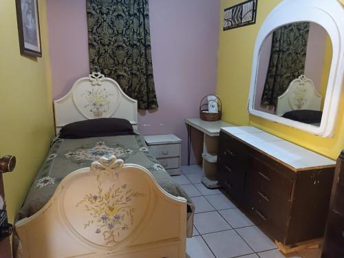a bedroom with a bed and a mirror at Hospedaje Barato Mi Casita de Colores in Tijuana