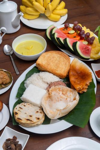 Una mesa de madera con platos de comida encima. en COLOMBO Eco Lodge & Wellness Centre, en Colombo