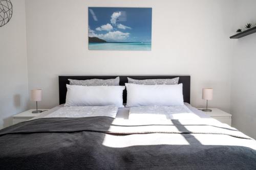 a bedroom with a large bed with two lamps at Dachgeschosswohnung mit Klimaanlage-15min vom Europa Park entfernt in Kenzingen