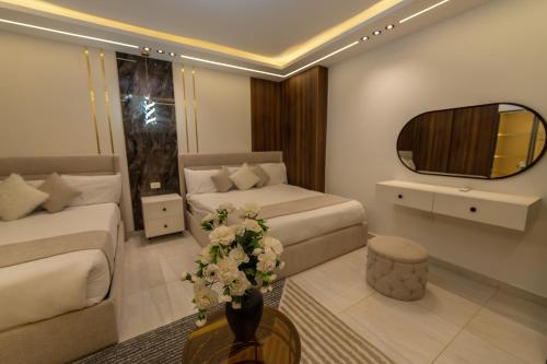a living room with two beds and a table with flowers at The Muse Luxury View Hotel in Cairo