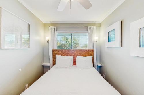 Un dormitorio con una cama con sábanas blancas y una ventana. en Sea Cabin 227-B, en Isle of Palms