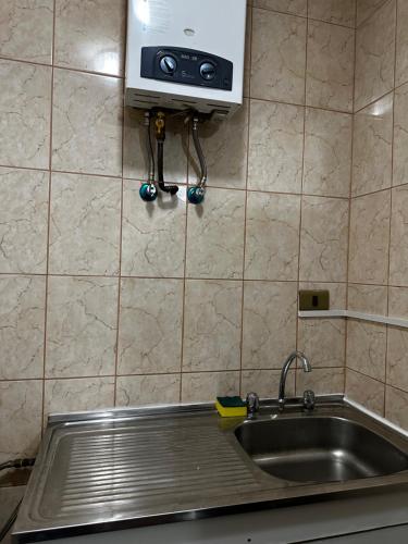 a kitchen with a sink and a microwave at Hostal Verde Bendito Depto 2 Temuco in Temuco