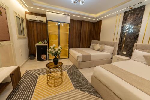 a hotel room with two beds and a table with flowers at The Muse Luxury View Hotel in Cairo