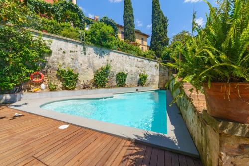 a swimming pool on a wooden deck with plants at Hotel Villa Sermolli in Borgo a Buggiano