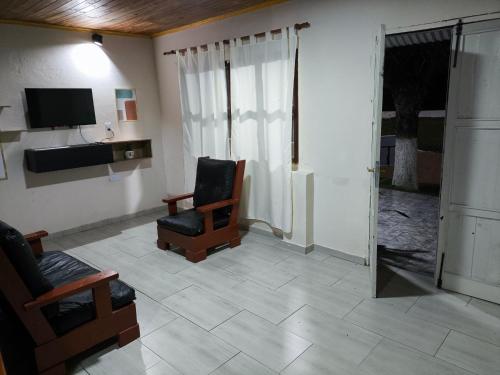 a living room with a chair and a television at Lo de Toty 2 in Yapeyú