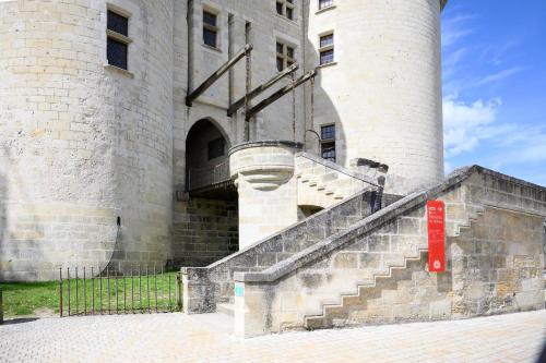 a castle with stairs in front of a building at L'Atelier du Château in Langeais