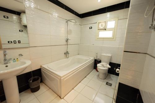 a white bathroom with a tub and a sink at The Muse Luxury View Hotel in Cairo