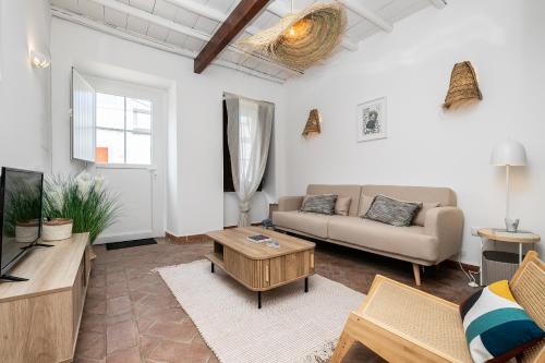 a living room with a couch and a tv at Casa das Letras by east ALgarve guest in Tavira