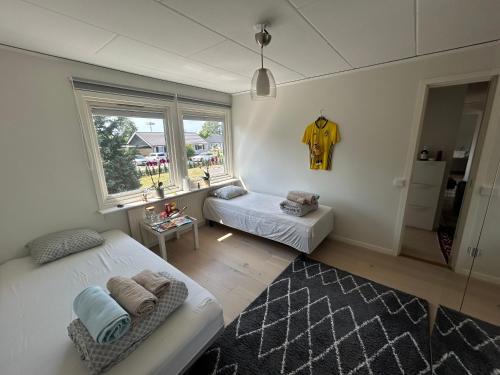 a bedroom with two beds and a window and a table at Sovrum i villa in Kalmar
