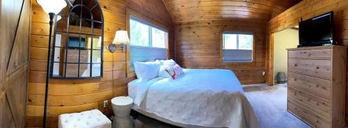 a bedroom with a white bed in a wooden room at Family Friendly Charming Truckee Getaway Walk to Shops & Dining in Meadow Lake Park