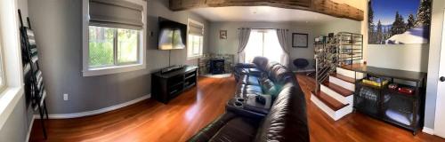 a living room with a leather couch and a television at Family Friendly Charming Truckee Getaway Walk to Shops & Dining in Meadow Lake Park