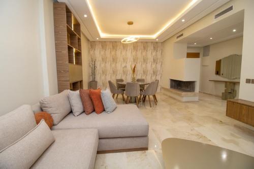 a living room with a couch and a table at Calme & Cocon Apartment Near Airport in Nouaceur