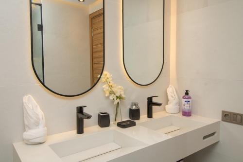 a bathroom with a white sink and two mirrors at Calme & Cocon Apartment Near Airport in Nouaceur