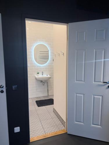 a bathroom with a sink and a door leading to a bathroom at Apartments24 Black 1903 in Rakvere