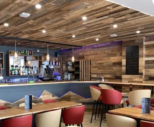 a restaurant with tables and chairs and a bar at Hôtel du Centre - Restaurant Lelex'ir in Lélex
