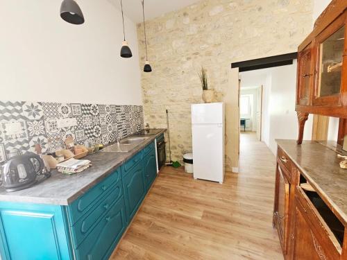 a kitchen with blue cabinets and a white refrigerator at Gîte à la ferme - 4 pers - Marsanne in Marsanne