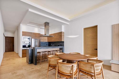 a kitchen and dining room with a wooden table and chairs at 2 Bedroom Residence Live Aqua La Paz in La Paz