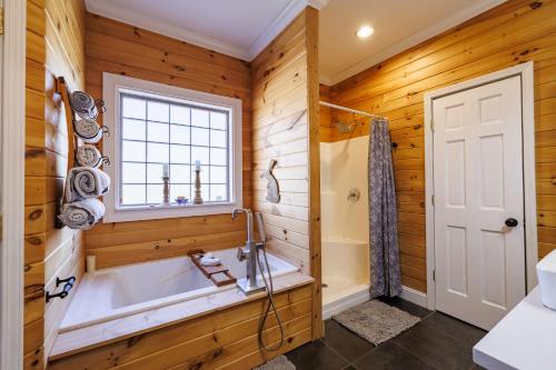 La salle de bains est pourvue d'une baignoire et d'une fenêtre. dans l'établissement Bird House - Hot Tub, Large Yard, Horses Nearby, à Mentone