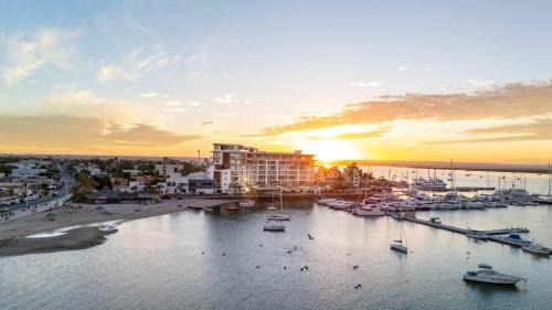 a group of boats in a marina at sunset at 2 Bedroom Residence Live Aqua La Paz in La Paz