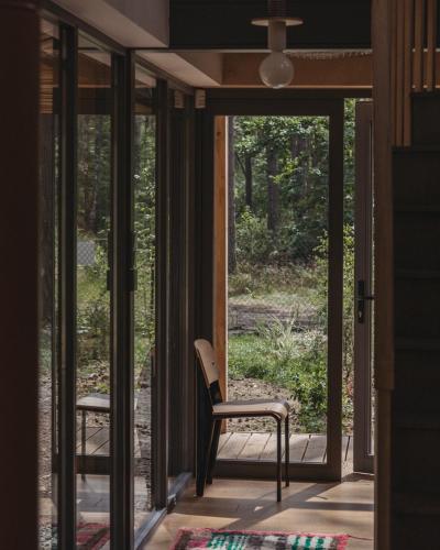 a room with glass doors and a chair on a porch at HATTA Las in Gąsiorowo Duże