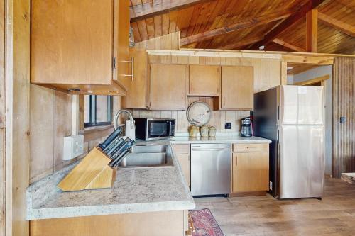 a kitchen with a stainless steel refrigerator and wooden cabinets at Lakefront Cabin Retreat (Cabin A) in Vallecito