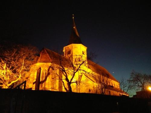 a church with a steeple lit up at night at Ferienwohnung Wetterisch in Weinsberg