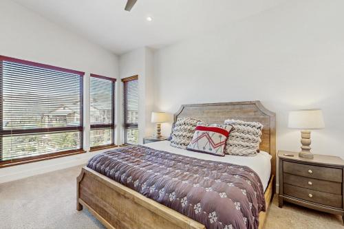 Un dormitorio con una cama y dos ventanas. en Traverse 1462, en Steamboat Springs