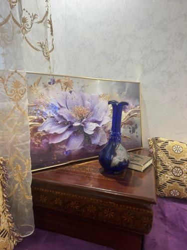 a blue vase sitting on a table next to a painting at Near Bus Station Apartments in Tangier