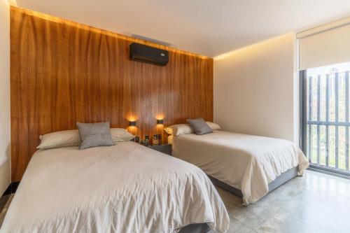 two beds in a room with wood paneling at Zielo 1Bdrm 1bath fits 6 AC Rooftop views in Mexico City
