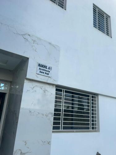 a white building with a sign on the side of it at Near Bus Station Apartments in Tangier