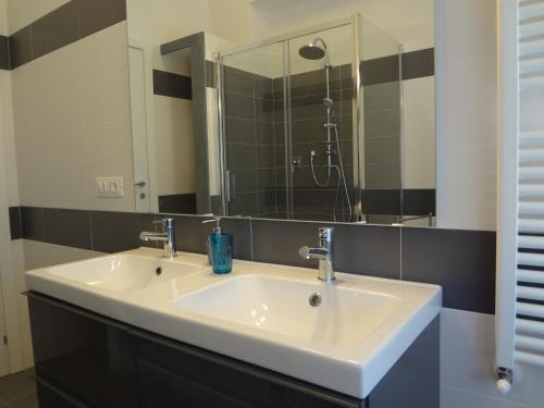 a bathroom with a white sink and a mirror at La Pineta Apartment in Viareggio