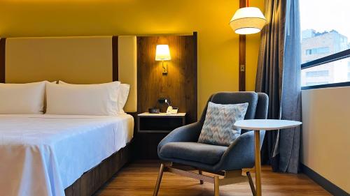 a bedroom with a bed and a chair and a table at Holiday Inn Mexico City-Plaza Universidad by IHG in Mexico City