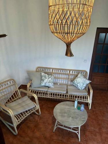 a living room with a couch and chairs and a chandelier at Bem estar 3 in Chaves