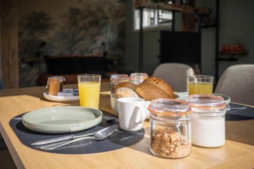 a table with a breakfast of bread and glasses of orange juice at B&B Het Boompje in Wervershoof