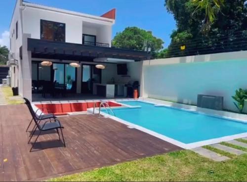 a villa with a swimming pool in front of a house at Island Crib - Luxury Villa for Stays & Events in La Ceiba