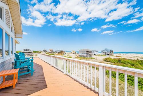 a deck with a bench and the beach at Ocean Aire in Knotts Island