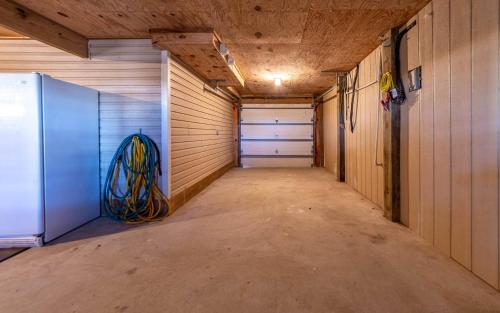 an empty garage with a garage door and a refrigerator at Ocean Aire in Knotts Island