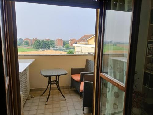 a balcony with a table and a chair and a window at Casa Raffaele in Borgaro Torinese