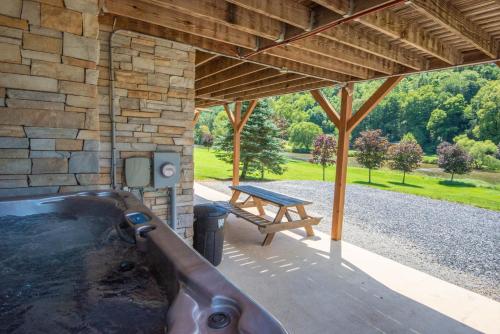 a hot tub in a stone building with a picnic table at Cabin on New River, Fire Pit, Dogs OK, Hot Tub with VIEWS - Sleeps 10 in Piney Creek